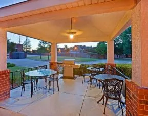 The hotel’s gazebo provides outdoor tables and chairs under cover, with greenery nearby and a barbecue.