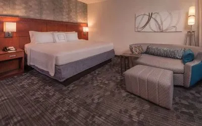 Double bed guest room in Sonesta Select Arlington Rosslyn, furnished with wall art, sofa, and coffee table.