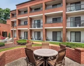 The hotel patio is close to the rooms, and has a circular table surrounded by a quintet of chairs.