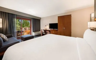 Double bed guest room in Sonesta Select San Jose Airport, with workspace desk and chair, plus TV.
