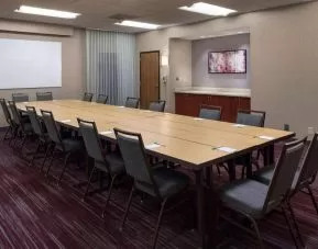 Meeting room in Sonesta Select Boston Milford, furnished with seating for 16 attendees, a long table, and a whiteboard.