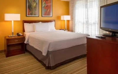 Double bed guest room in Sonesta ES Suites Charlottesville University, featuring window and widescreen TV.