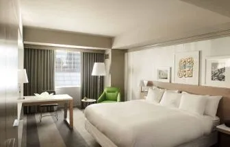 Royal Sonesta Minneapolis Downtown deluxe king guest room, with workspace desk and chair, and art on the wall.