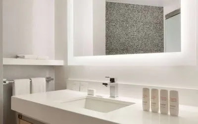 Guest bathroom in the hotel, including a range of toiletries, towels, and a sink.