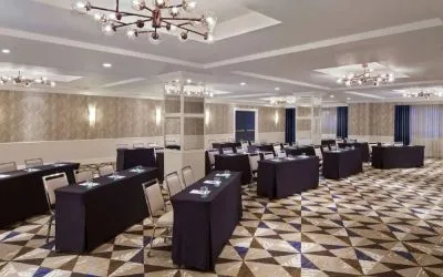 Large meeting room in Royal Sonesta Washington DC Dupont Circle, with tables of three seats each arranged in a classroom style.