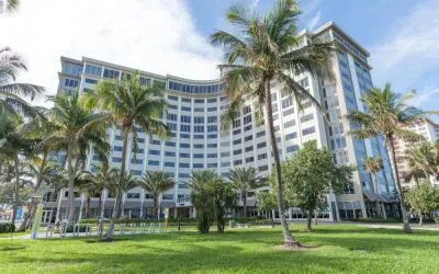 Sonesta Fort Lauderdale Beach’s exterior has extensive greenery, including numerous palm trees.