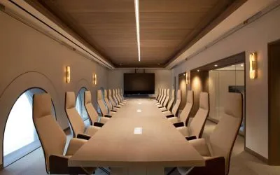 Meeting room in The Clift Royal Sonesta, featuring long table with seating for over a dozen attendees, cozy atmosphere, and large, wall-mounted TV.
