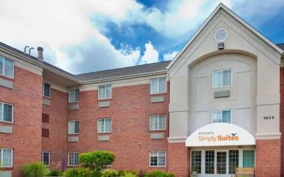 Sonesta Simply Suites Des Moines’ exterior has pleasant greenery, parking, and red brick architecture.
