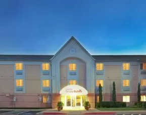 Sonesta Simply Suites Dallas Galleria’s exterior has well-kept greenery, including potted plants, clear signage, and parking spaces.