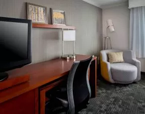 Sonesta Select Tinton Falls Eatontown guest room workspace, with desk, chair, and lamp, and TV.