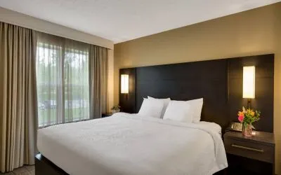 Double bed guest room in Sonesta ES Suites Parsippany Morris Plains, with bedside lighting and a large window.