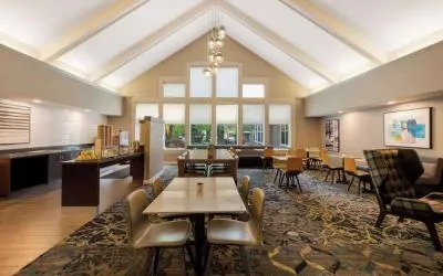 The hotel’s breakfast area is spacious and has large windows, with tables varying from two seats to eight, and art on the wall.