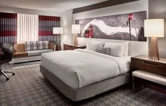 Double bed guest room in Sonesta Philadelphia Rittenhouse Square, including art on the wall, bedside lamps, chair, and a sofa.