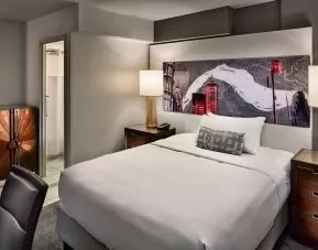 Sonesta Philadelphia Rittenhouse Square double bed guest room, featuring art on the wall, chair, and ensuite bathroom.