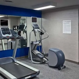 The hotel fitness center is equipped with towels, gym balls, and exercise machines such as an elliptical and a treadmill.