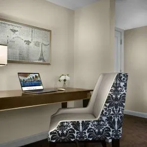 The Chase Park Plaza Royal Sonesta St. Louis guest room workspace, furnished with desk, chair, and lamp.