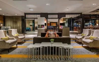 Sonesta Charlotte Executive Park’s lobby lounge is furnished with comfortable armchair and sofa seating for guests to relax and socialize.