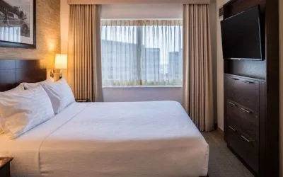 Sonesta Chicago O'Hare Airport Rosemont double bed guest room with window and wall-mounted TV.
