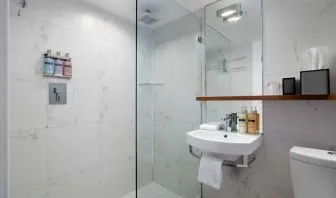 Guest bathroom in Nautilus by Sonesta, including shower, sink, mirror, and lavatory.