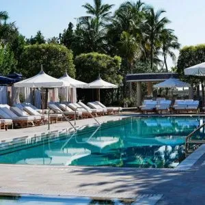 Nautilus by Sonesta’s outdoor pool has sun loungers (with shade available) by the side, and palm trees looming in the background.
