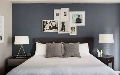 The Shelburne Sonesta New York double bed guest room, with art on the walls and bedside lamps.
