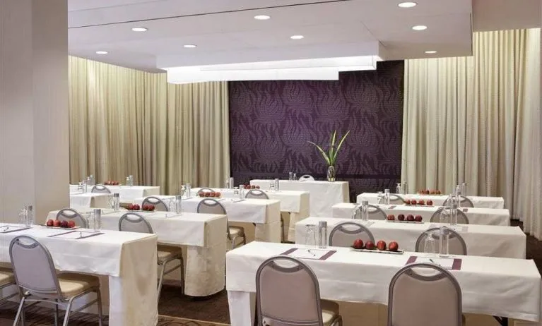 The Shelburne Sonesta New York meeting room with tables arranged in a classroom style facing a head table and space for over a dozen attendees.