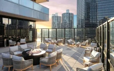 The hotel terrace offers elevated city views and comfy seating beside coffee tables, plus a fire pit.