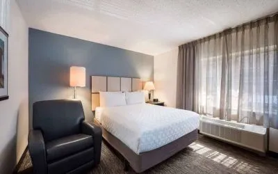 Double bed guest room in Sonesta Simply Suites Phoenix Tempe, featuring an armchair and a window.