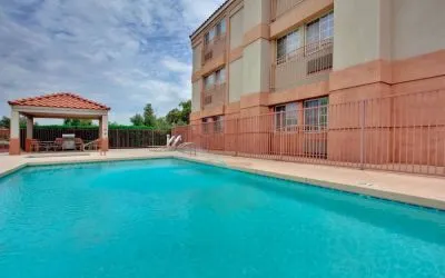 The outdoor pool at Sonesta Simply Suites Phoenix Tempe has sun loungers by the side, and is close to the gazebo and barbecue facilities.