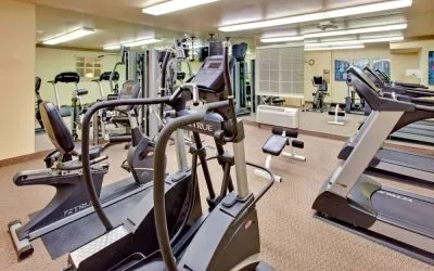 Sonesta Simply Suites Phoenix Tempe’s fitness center has a mirrored wall and a range of exercise equipment.