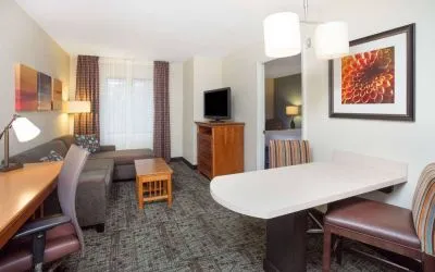 Sonesta ES Suites Atlanta - Perimeter Center double bed guest room, with living area that has a desk and chair, sofa, coffee tables, window, and TV.