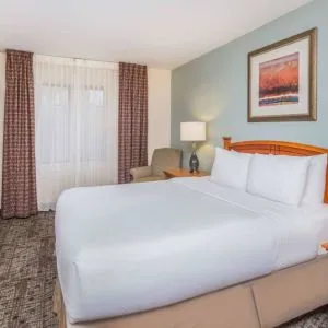 Sonesta ES Suites Atlanta - Perimeter Center double bed guest room, featuring TV, armchair, and window.
