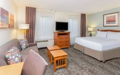 Double bed guest room in Sonesta ES Suites Atlanta - Perimeter Center, including coffee tables, windows, TV, and sofa.