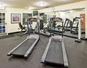 Sonesta ES Suites Atlanta Alpharetta Avalon’s fitness center is equipped with a range of exercise machinery and a wall-mounted television.