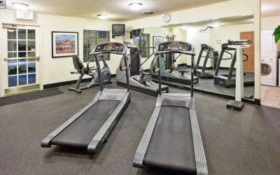 Sonesta ES Suites Atlanta Alpharetta Avalon’s fitness center is equipped with a range of exercise machinery and a wall-mounted television.