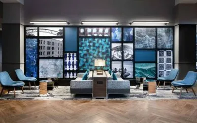 The hotel’s lobby lounge is furnished with comfortable chairs and sofa seating, with coffee tables and a wall filled with predominantly architecture-themed artwork.