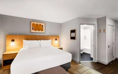 Double bed guest room in Sonesta Simply Suites Austin South, featuring art on the wall and an ensuite bathroom.