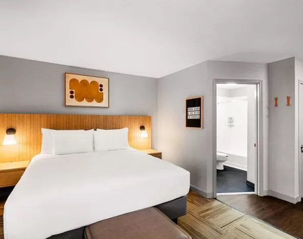 Double bed guest room in Sonesta Simply Suites Austin South, featuring art on the wall and an ensuite bathroom.
