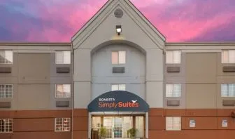The hotel’s exterior includes potted plants by the front door, above which is the name Sonesta Simply Suites.