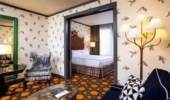 Double bed guest room in Royal Sonesta Portland Downtown, including a living area with sofa, coffee tables, and a chair.