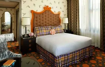 Royal Sonesta Portland Downtown double bed guest room, featuring chair, coffee table, and window.