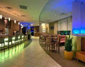 The hotel’s dining area has a mix of bar stool seating and tables and chairs, with subdued lighting providing a relaxed atmosphere.