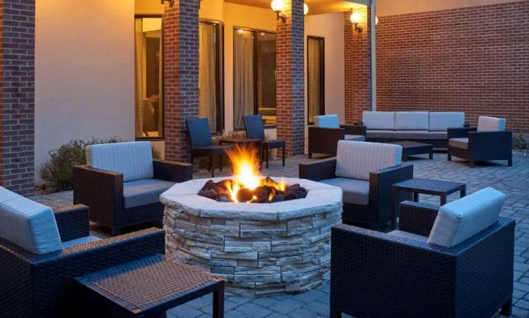 Sonesta Select Indianapolis Carmel’s patio features a fire pit and armchairs, plus coffee tables and sofa seating.