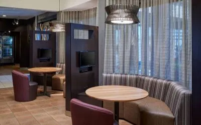 Sonesta Select Indianapolis Carmel’s media pods each feature a TV, coffee table, and comfortable seating next to a window.