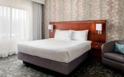 Sonesta Select Whippany Hanover double bed guest room, including chair and a large window.