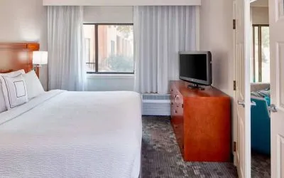 Double bed guest room in Sonesta Select Raleigh Durham Airport Morrisville, featuring a window and a television.