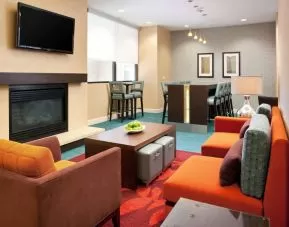 Sonesta ES Suites San Antonio Downtown Alamo Plaza’s lobby lounge has comfy seating, a fireplace, and a wall-mounted TV.