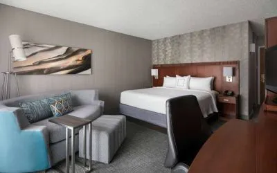 Sonesta Select Los Angeles LAX El Segundo double bed guest room including TV, chair, and sofa.