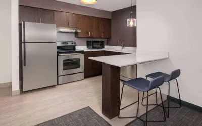 Sonesta ES Suites Atlanta Alpharetta North Point Mall guest room kitchen, fitted with fridge-freezer, microwave, oven, and table.