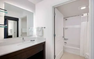 Guest bathroom in Sonesta ES Suites Atlanta Alpharetta North Point Mall featuring shower-equipped bath, lavatory, mirror, and sink.